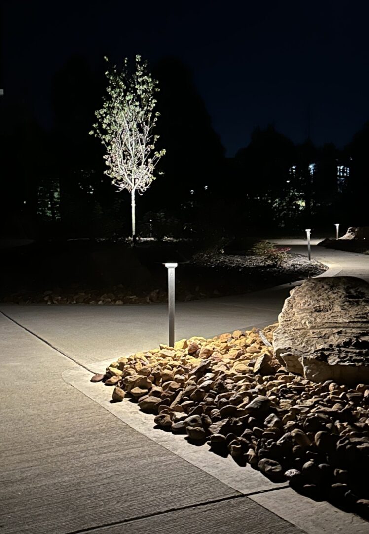 A stone path lit up at night with lights.