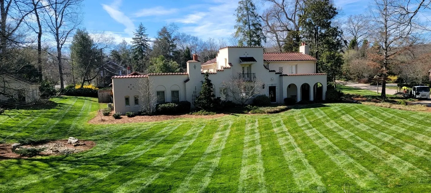 A large white house with a lawn in front of it.