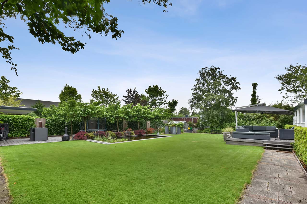 the-backyard-of-the-house-with-a-large-green-lawn-2023-11-27-05-08-30-utc